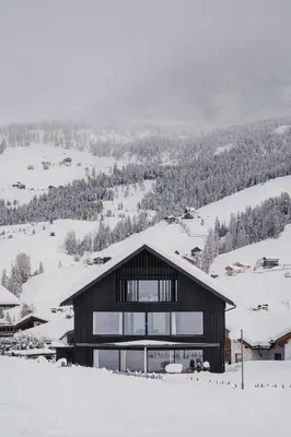 a house on top of a snow covered mountain at Larix Lodge in La Villa