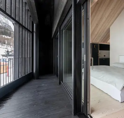 a bedroom with a bed and a balcony at Larix Lodge in La Villa