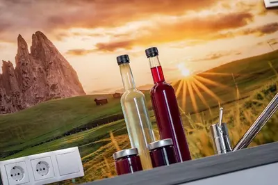 a table with a bottle of wine on it with mountains in the background at Foreserhof in Fiè