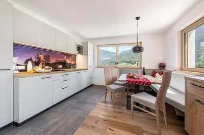 a kitchen and dining room with a table and chairs at Foreserhof in Fiè