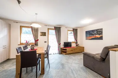 a living room with a table and a couch at Cèsa Baissa in Campitello di Fassa
