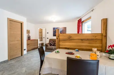 a dining room with a table and chairs at Cèsa Baissa in Campitello di Fassa
