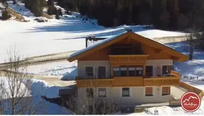 a house in the snow with snow at Apartments Oberhollenzer in Braies
