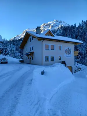 a house with snow on the ground in front of it at Apartments Oberhollenzer in Braies