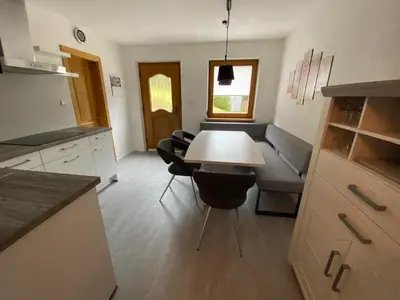a kitchen and living room with a table and a couch at Apartments Oberhollenzer in Braies