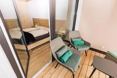a small room with a bed and two chairs at Baumgartnerhof Sauvigon in Cortaccia
