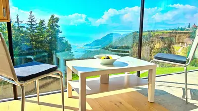 a table and two chairs in front of a large window at Vidora Apartments in Soprabolzano