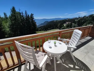 a white table and two chairs on a balcony at Vidora Apartments in Soprabolzano