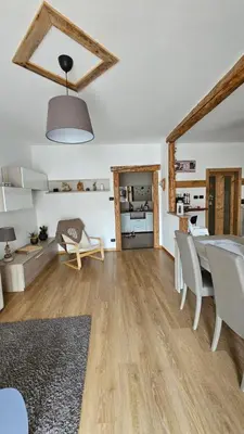 a living room with a table and chairs and a kitchen at Appartamento 