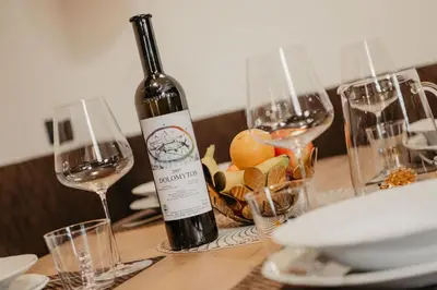 a bottle of wine sitting on a table with glasses at Dolomites Chalet Niuasi in Ortisei