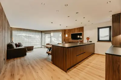 a kitchen and living room with a couch and a table at Dolomites Chalet Niuasi in Ortisei