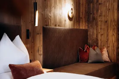 a bedroom with a bench with pillows on it at Dolomites Chalet Niuasi in Ortisei
