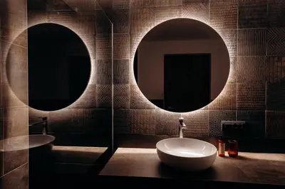 a bathroom with two round mirrors and a sink at Dolomites Chalet Niuasi in Ortisei