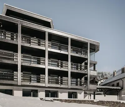an apartment building with balconies on the side of it at Dolomites Chalet Niuasi in Ortisei