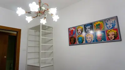 a painting hanging on a wall next to a ladder at Meran/o Centro Guest House in Merano