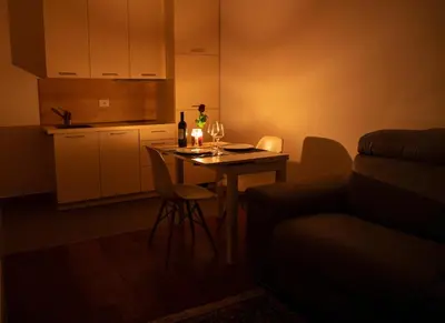 a kitchen with a table with wine glasses and a couch at Meran/o Centro Guest House in Merano