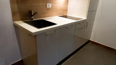 a small kitchen with a sink and a refrigerator at Meran/o Centro Guest House in Merano
