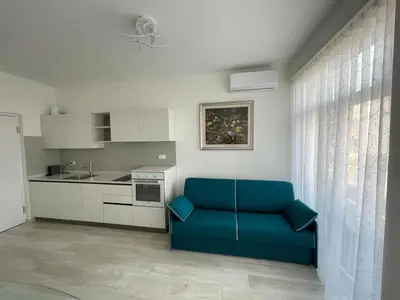 a living room with a blue couch in a kitchen at CASA VITTORIA - SIEGESHAUS in Bolzano