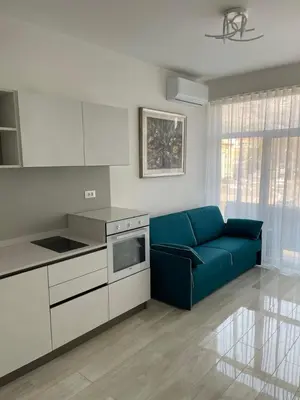a living room with a blue couch in a kitchen at CASA VITTORIA - SIEGESHAUS in Bolzano