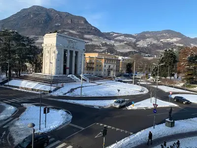 a snow covered city with a mountain in the background at CASA VITTORIA - SIEGESHAUS in Bolzano