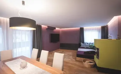 a dining room with a table and a bedroom at Dolce Vita Apartment in Valdaora