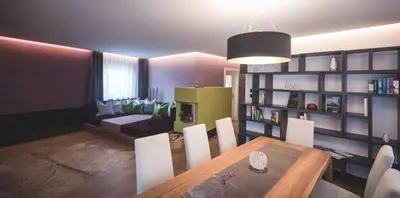 a living room with a dining table and a couch at Dolce Vita Apartment in Valdaora