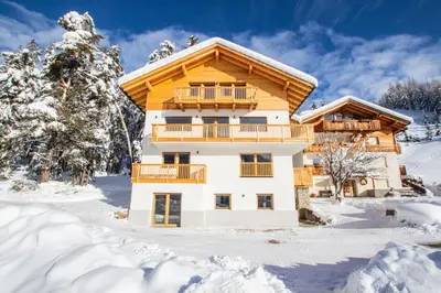 a house in the snow with snow covered trees at Niciora in Badia