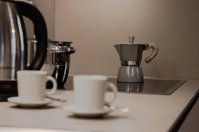 two cups on a kitchen counter with a coffee pot at Niciora in Badia