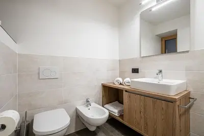 a bathroom with a sink and a toilet and a mirror at Niciora in Badia