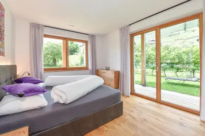 a bedroom with two beds and a large window at Ferienwohnungen Ortsried in Nalles