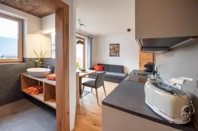 a kitchen and living room with a counter and a table at Ferienwohnungen Ortsried in Nalles