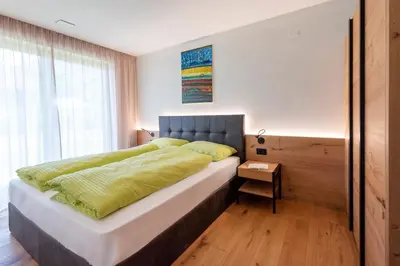 a bedroom with a large bed with a blue headboard at Ferienwohnungen Ortsried in Nalles
