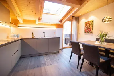 a kitchen with a sink and a table with chairs at Ferienwohnungen Ortsried in Nalles