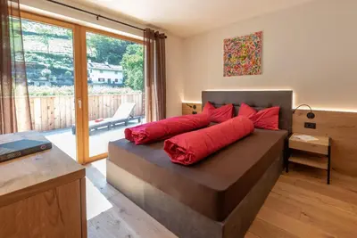 a bedroom with a bed with red pillows on it at Ferienwohnungen Ortsried in Nalles