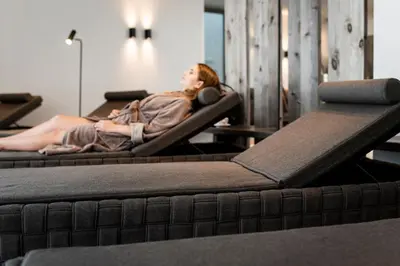 a woman laying in beds in a room at Surega - Idyllic Farmhouse in San Cassiano