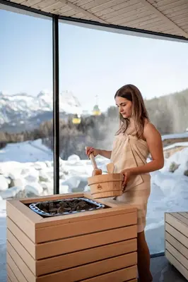 a woman standing in front of a stove with a box at Surega - Idyllic Farmhouse in San Cassiano