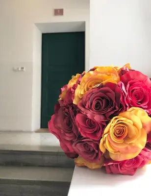 a large bouquet of red and yellow roses in front of a door at Rosengarten Apartments in Bolzano