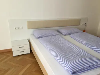 a bedroom with two beds and a night stand at Rosengarten Apartments in Bolzano
