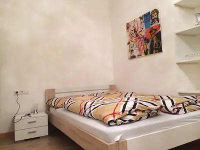 a bedroom with a bed and a painting on the wall at Rosengarten Apartments in Bolzano