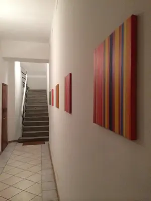 a hallway with three paintings on the wall at Rosengarten Apartments in Bolzano