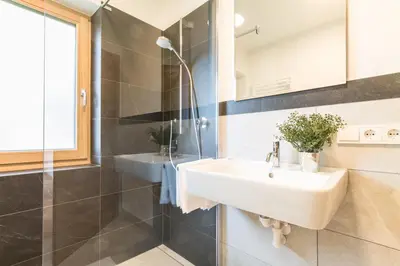 a bathroom with a sink and a glass shower at Apartment La Brunella in Laion