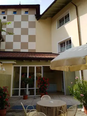 a table and chairs in front of a house at Hotel Turmwirt in Ora/Auer