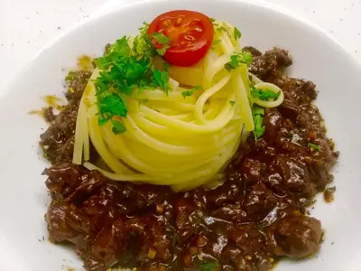 a white plate of food with pasta and beans at Hotel Turmwirt in Ora/Auer