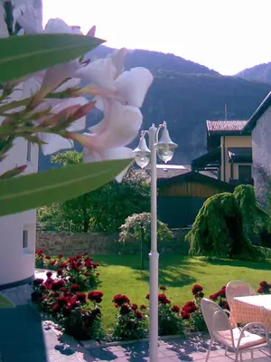 a table and chairs in a garden with a flower at Hotel Turmwirt in Ora/Auer