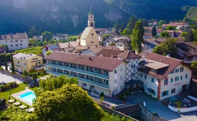 an aerial view of a village with a building and a church at Hotel Turmwirt in Ora/Auer