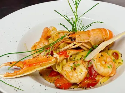 a plate of shrimp and vegetables on a plate at Hotel Turmwirt in Ora/Auer