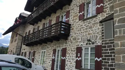 a building with red and white arrows painted on it at SUITE25 GOLFHOTEL in Carezza al Lago