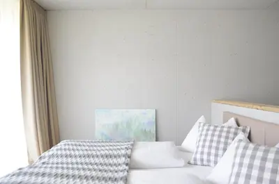 a bedroom with a white bed with checkered pillows at Apartments Etruska in Santa Cristina in Val Gardena