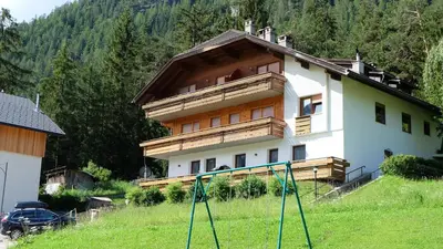 a house on a hill in front of a forest at Casa Tura San Vigilio in San Vigilio Di Marebbe