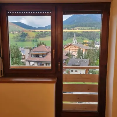 a window with a view of a town at Casa Tura San Vigilio in San Vigilio Di Marebbe